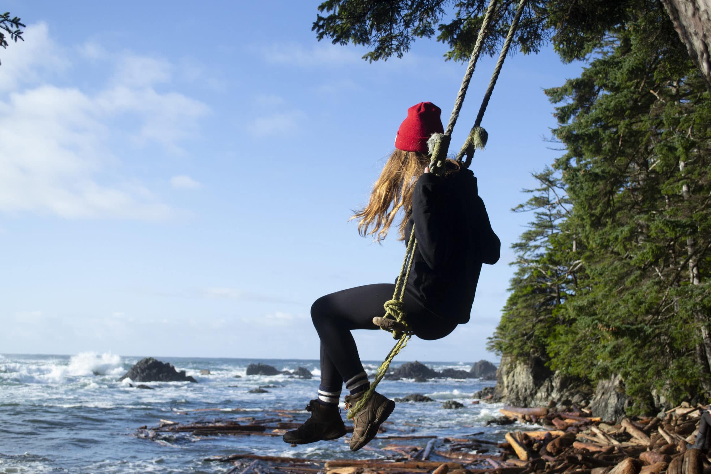 Emma swinging near ocean in tofino